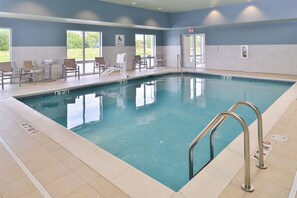A swimming pool with a pool lift, lounge chairs, and a view of the outdoors. - Holiday Inn Express & Suites Omaha Airport by IHG (Carter Lake)
