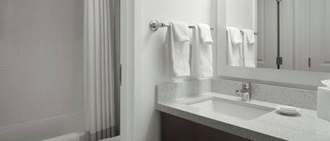 A modern bathroom with a shower, toilet, and sink.
