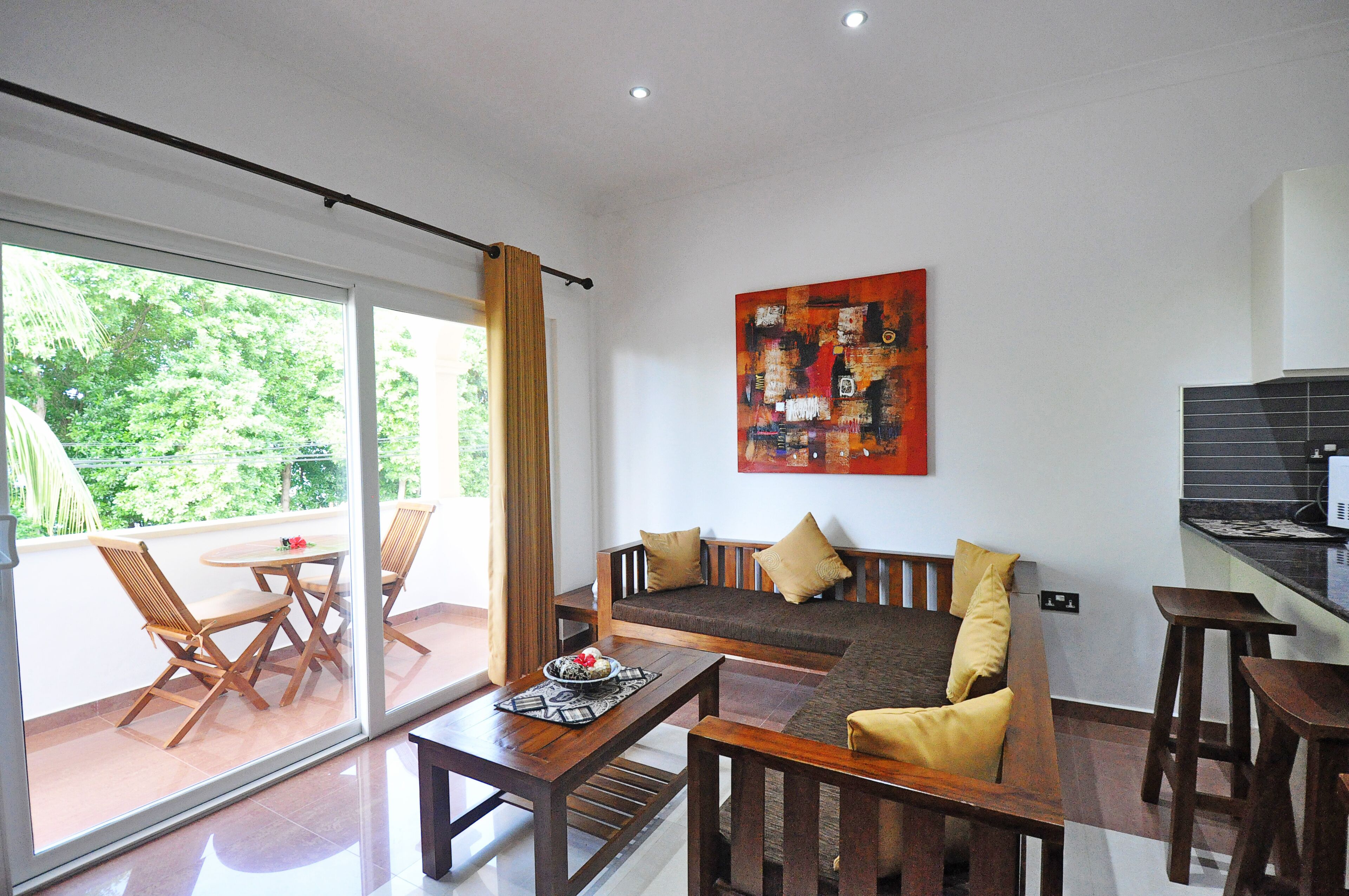 A modern living room with a sofa, wooden chairs, a coffee table, and a large window.