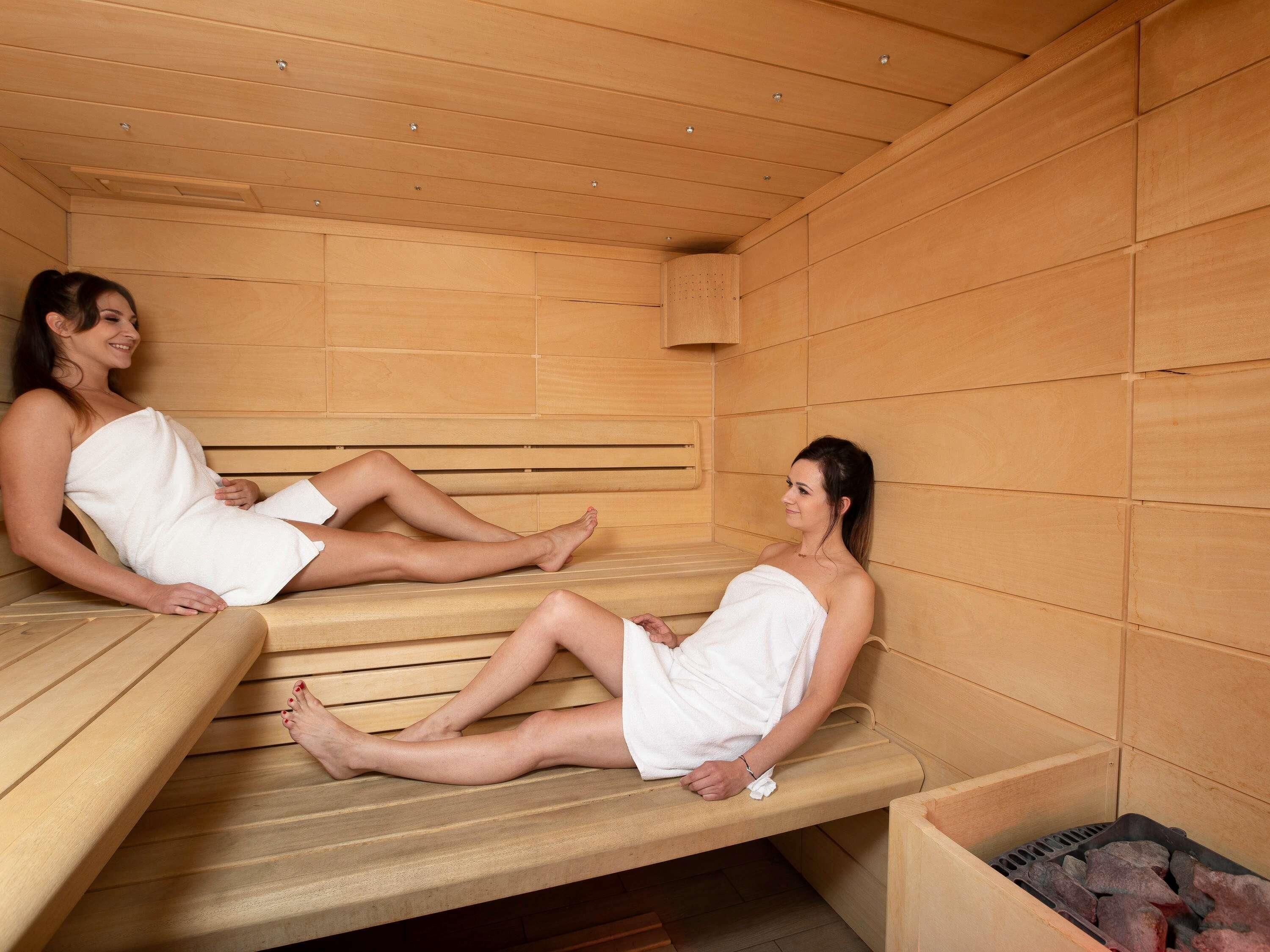 Two wooden benches in a sauna room with a wooden ceiling and walls.
