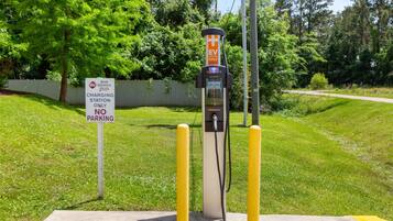 A charging station with a 'EV ONLY' sign, a 'No Parking' sign, and a 'Best Western Plus' sign.