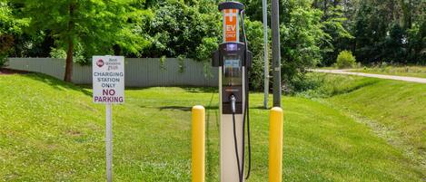 Une borne de recharge avec un panneau indiquant « Réservé aux véhicules électriques », un panneau indiquant « Stationnement interdit » et un panneau « Best Western Plus ».