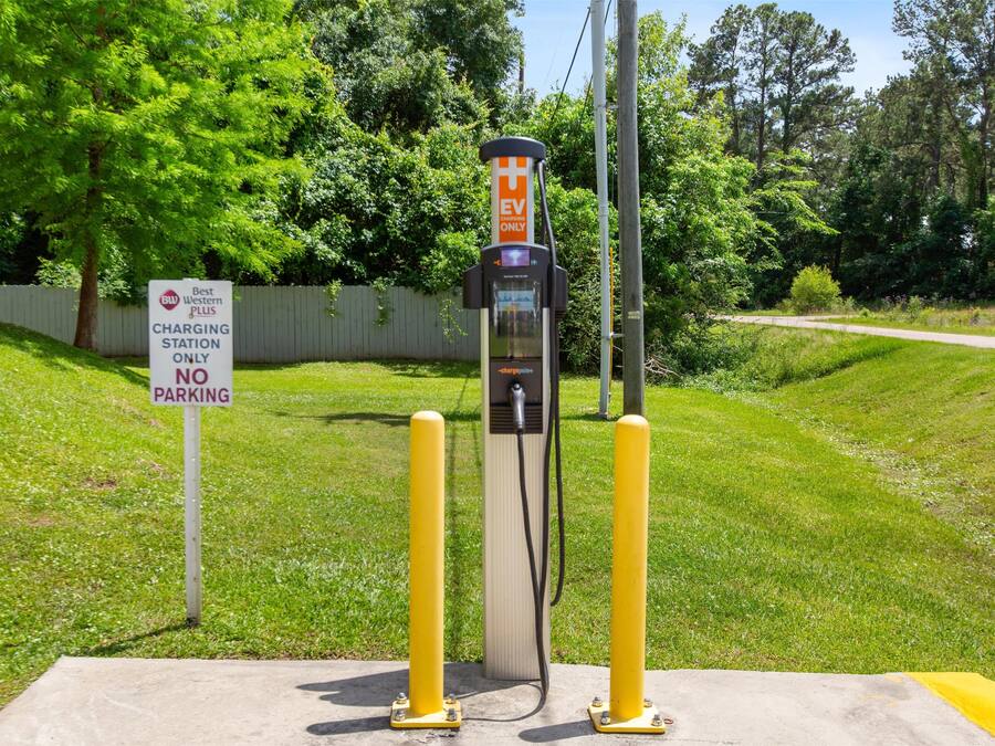 A charging station with a 'EV ONLY' sign, a 'No Parking' sign, and a 'Best Western Plus' sign.