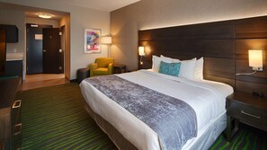A hotel room with a large bed, a desk, a chair, and a lamp. - Best Western Plus Prien Lake Hotel & Suites - Lake Charles (Lake Charles)