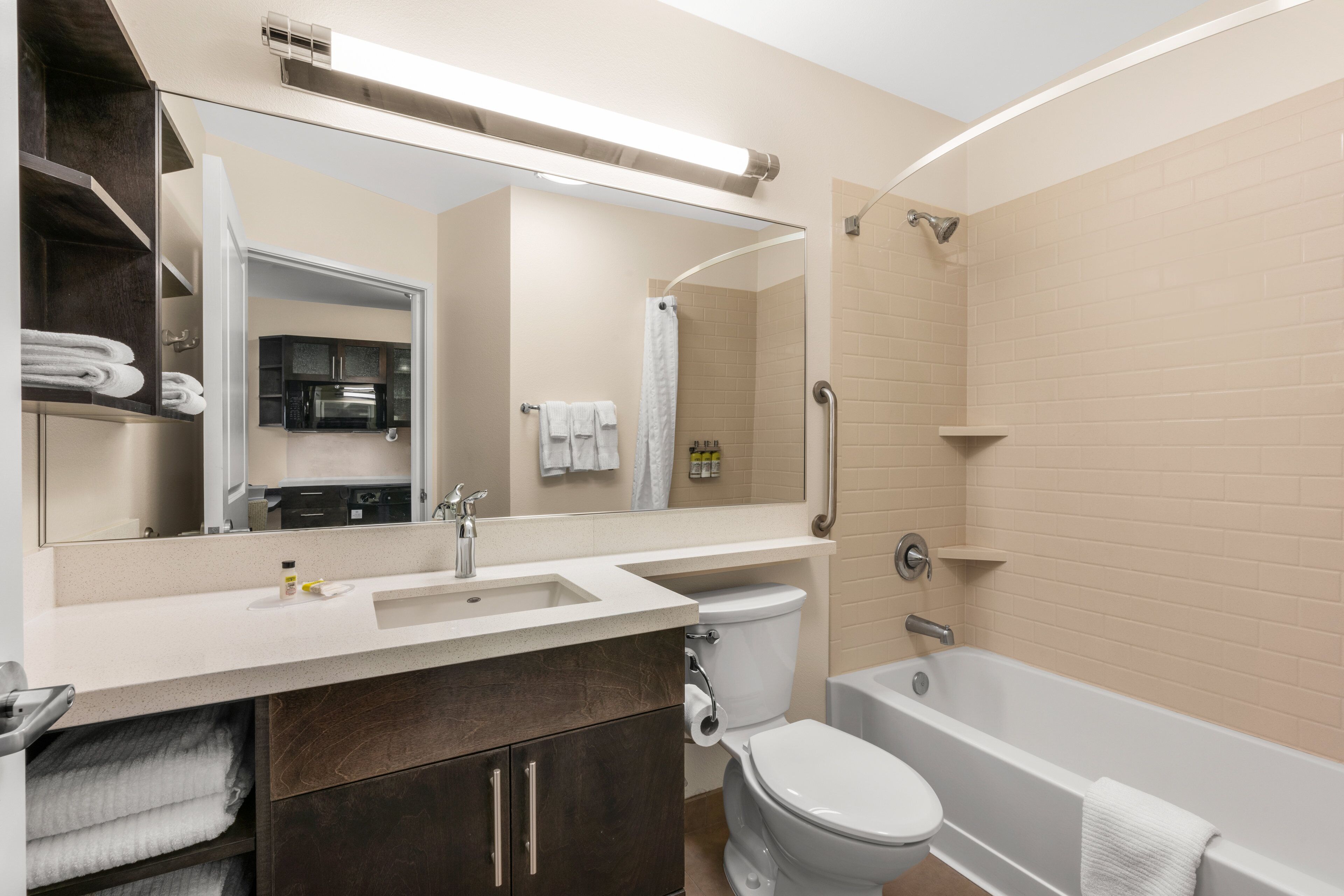 A modern bathroom with a vanity, sink, toilet, and bathtub.