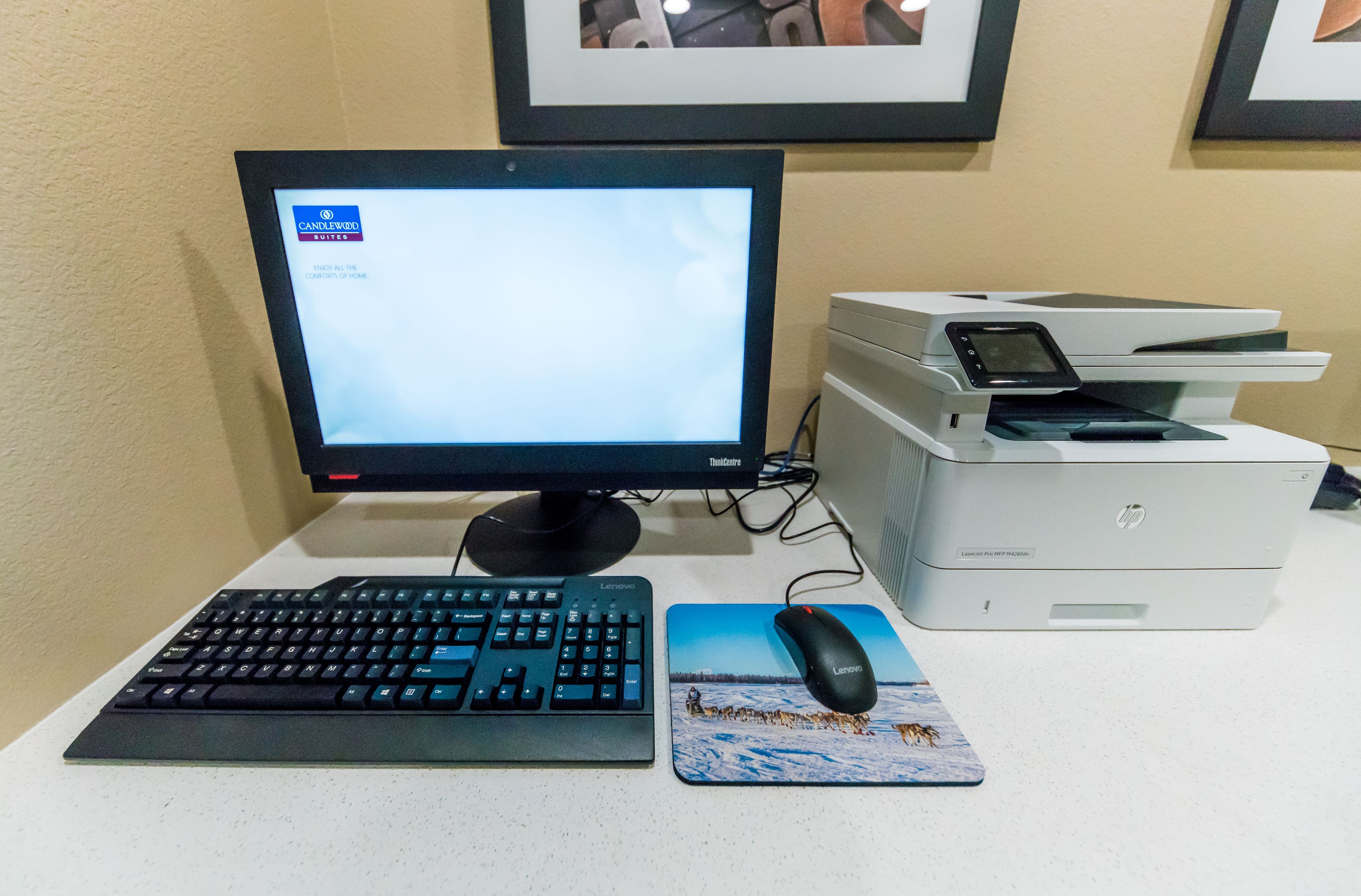 Un ordinateur de bureau avec un écran, un clavier, une souris et une imprimante, le tout posé sur un bureau.