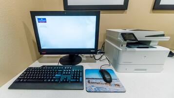 Un ordinateur de bureau avec un écran, un clavier, une souris et une imprimante, le tout posé sur un bureau.