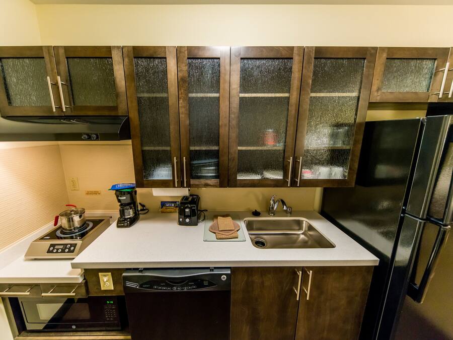 A compact kitchen with a stove, microwave, dishwasher, and a refrigerator.