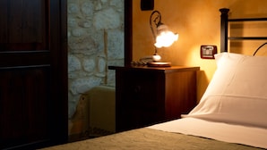 A bedroom with a wooden headboard, a bedside lamp, a nightstand, and a bed with white bedding. - Agriturismo Il Casolare Di Nonno Mario (Manoppello)