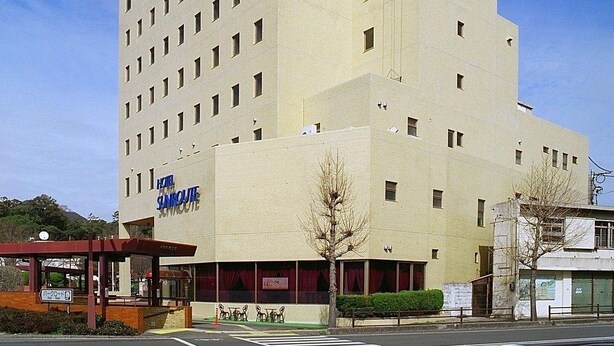 A multi-story hotel with a prominent sign reading "Hotel Sanquique."