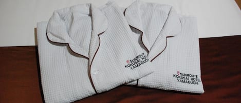 A pair of white towels with embroidered text indicating they are from Sunroute Kokusai Hotel Yamaguchi.