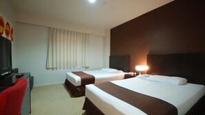A hotel room with two beds, a TV, a desk, and a window with curtains.