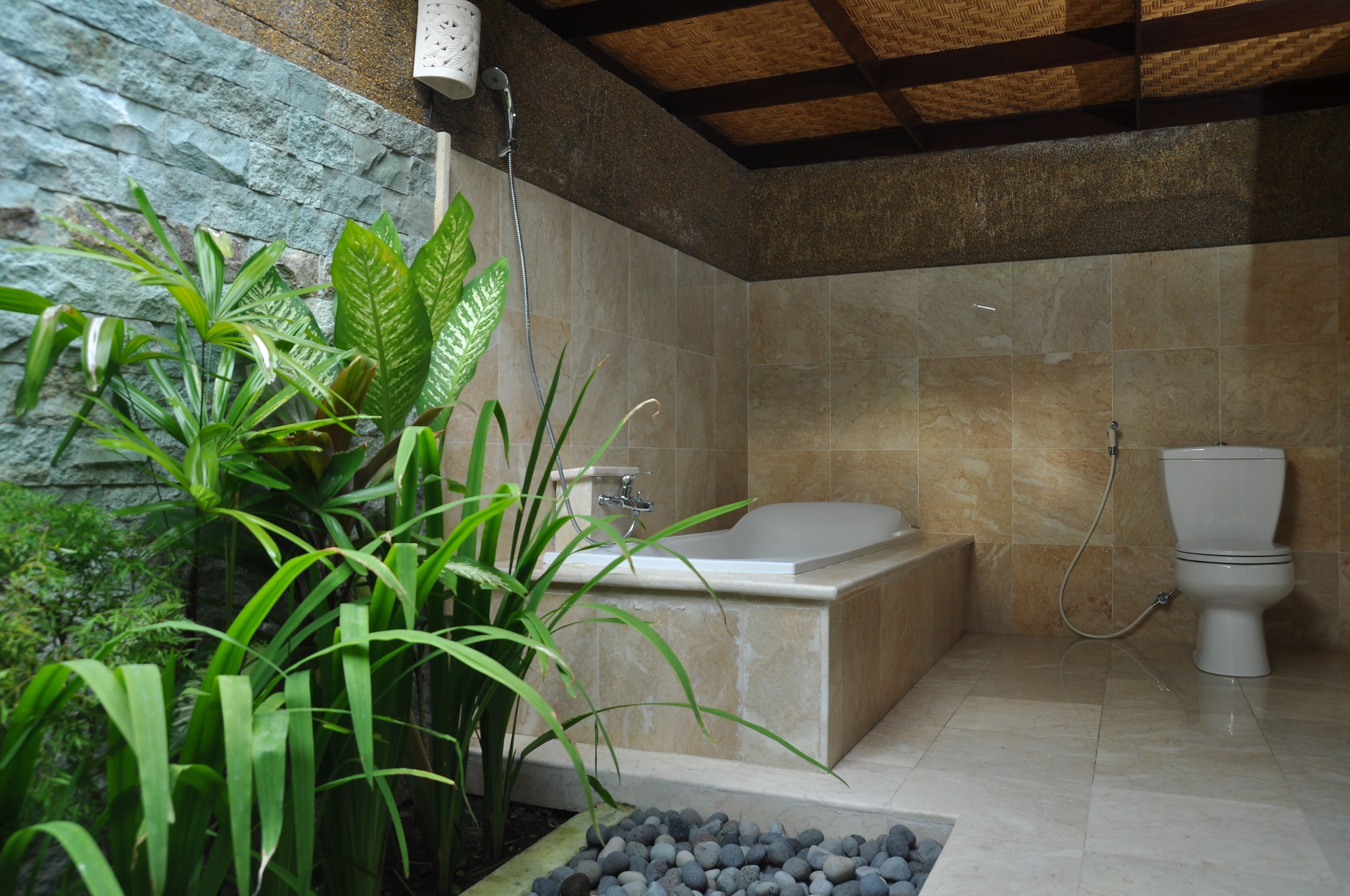 A modern bathroom with a bathtub, toilet, and shower.