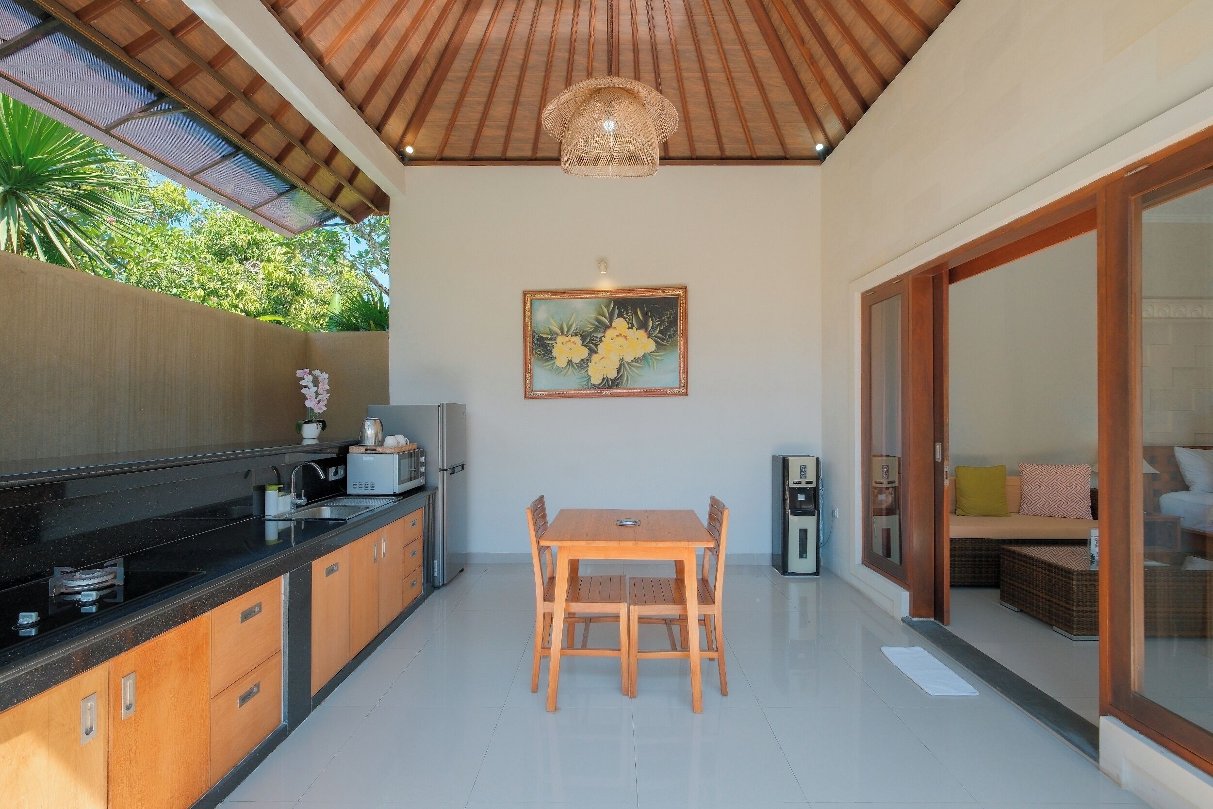 A kitchen with a dining table and chairs, a refrigerator, and a sink.