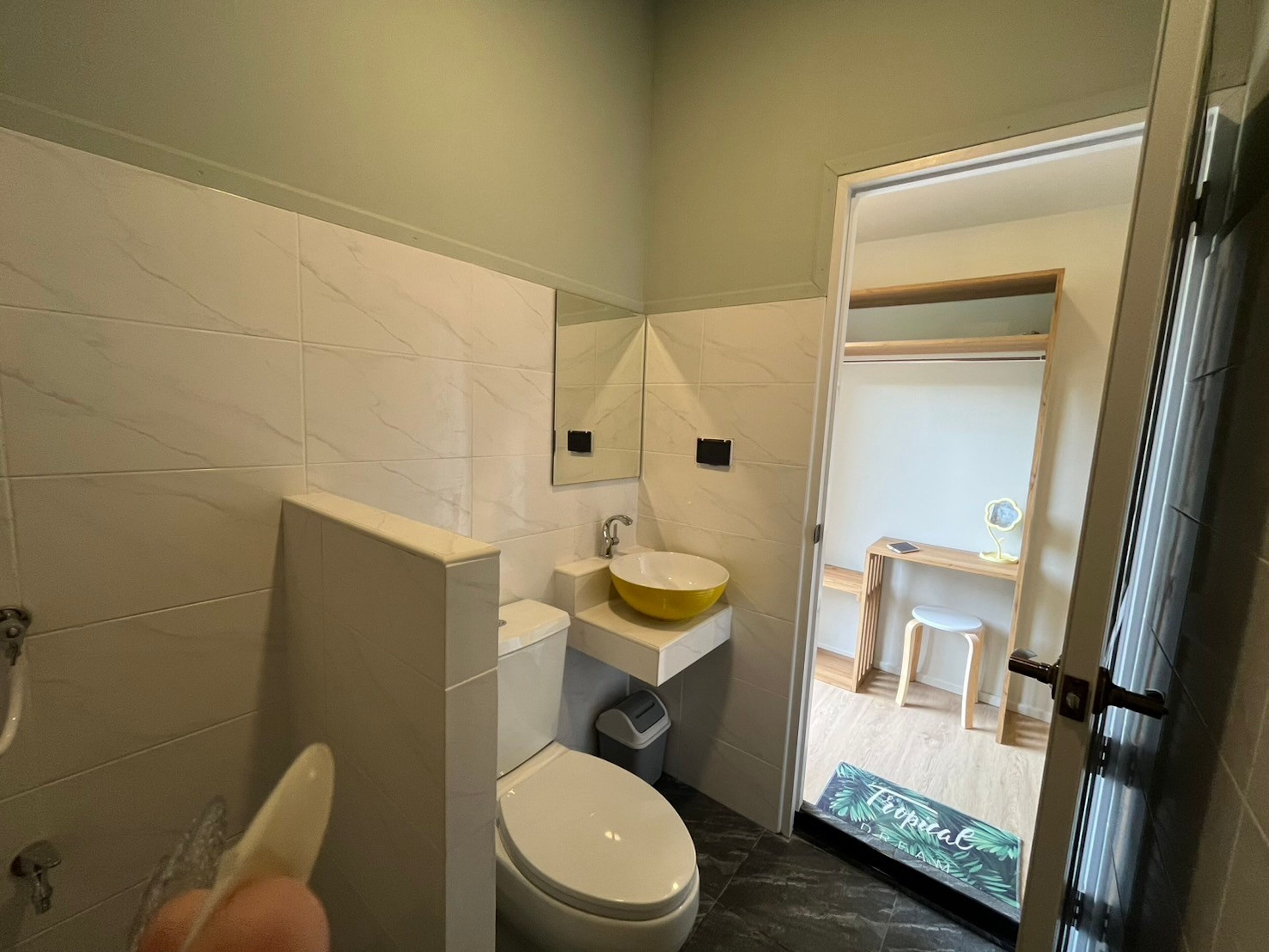 Un baño moderno con inodoro, lavamanos y zona de ducha.
