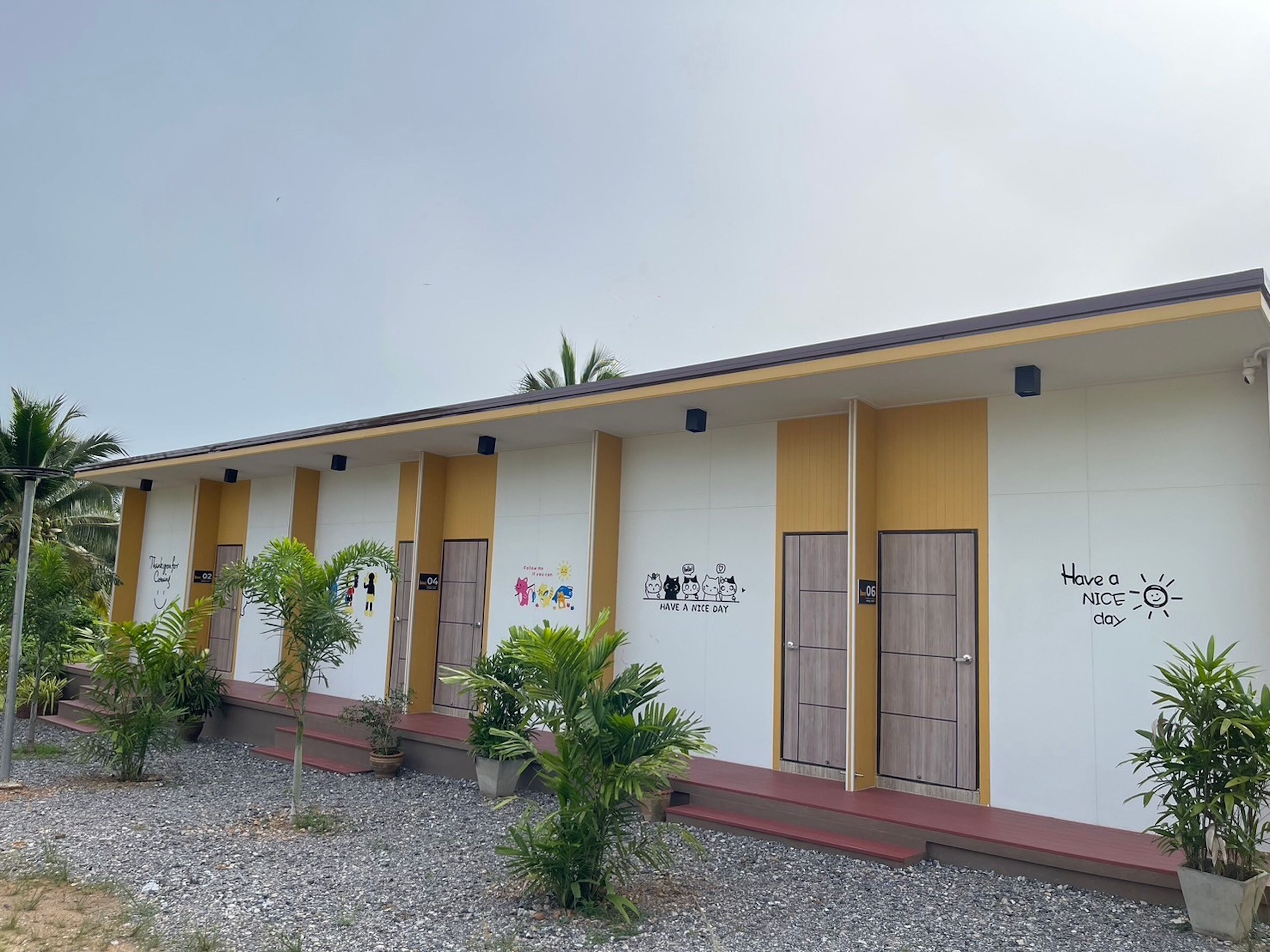 A row of hotel rooms with numbered doors, each with a unique wall decoration.