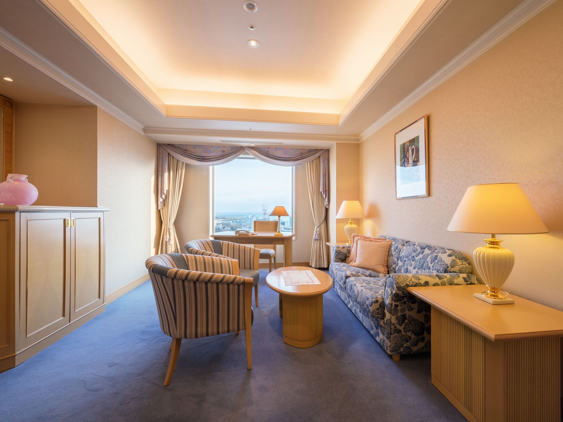 Ein Hotelzimmer mit einer Couch, einem Sessel und einem kleinen Tisch.