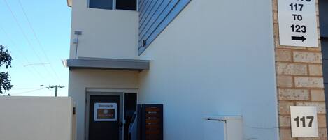 A building with a sign indicating 'WALDORF' and 'GERRITON'. There is a sign for 'UNITS 117 TO 123' and a door with a 'Welcome to WALDORF' sign.