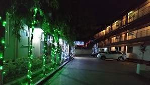 Un edificio con zona de estacionamiento y un coche dentro.