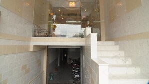A hotel lobby with a marble floor, a staircase, and a glass elevator. - Song Anh 3 Hotel (Ho Chi Minh City)