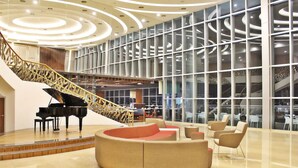 A spacious lobby with a grand piano, a curved seating area, and a staircase with a unique design. - Holiday Villa Johor Bahru City Centre (Johor Bahru)