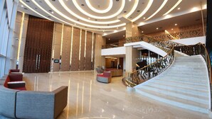 A spacious lobby with a curved staircase and modern seating areas. - Holiday Villa Johor Bahru City Centre (Johor Bahru)