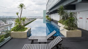 A rooftop infinity pool with lounge chairs, surrounded by potted plants, overlooking a cityscape. - Holiday Villa Johor Bahru City Centre (Johor Bahru)