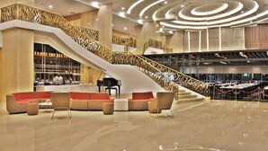 A spacious lobby with a curved staircase, seating area, and a piano. - Holiday Villa Johor Bahru City Centre (Johor Bahru)