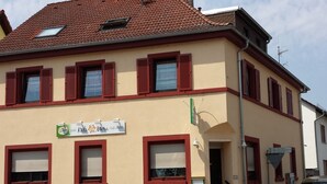 A two-story building with a sign for Hotel Kalihera Cafe-Bistro. - Hotel Kalimera (Heddesheim)