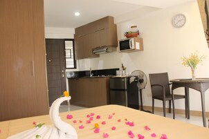 Una cocina compacta con electrodomésticos modernos, un comedor con mesa y sillas, y un centro de mesa decorativo con forma de cisne.