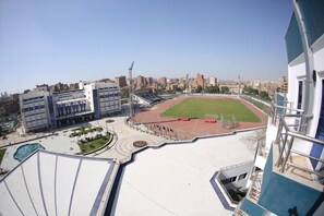 A stadium with a running track and seating areas, surrounded by buildings and a clear sky. - Tolip Inn Maadi (Cairo)