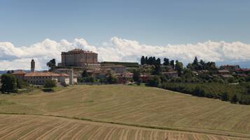 A historic town with a prominent building with a clock tower, surrounded by rolling hills and fields.