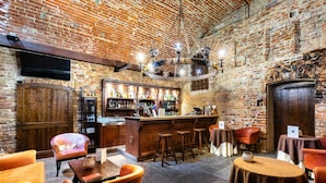 Um espaço de bar rústico, com paredes de tijolo, mobiliário de madeira e balcão.