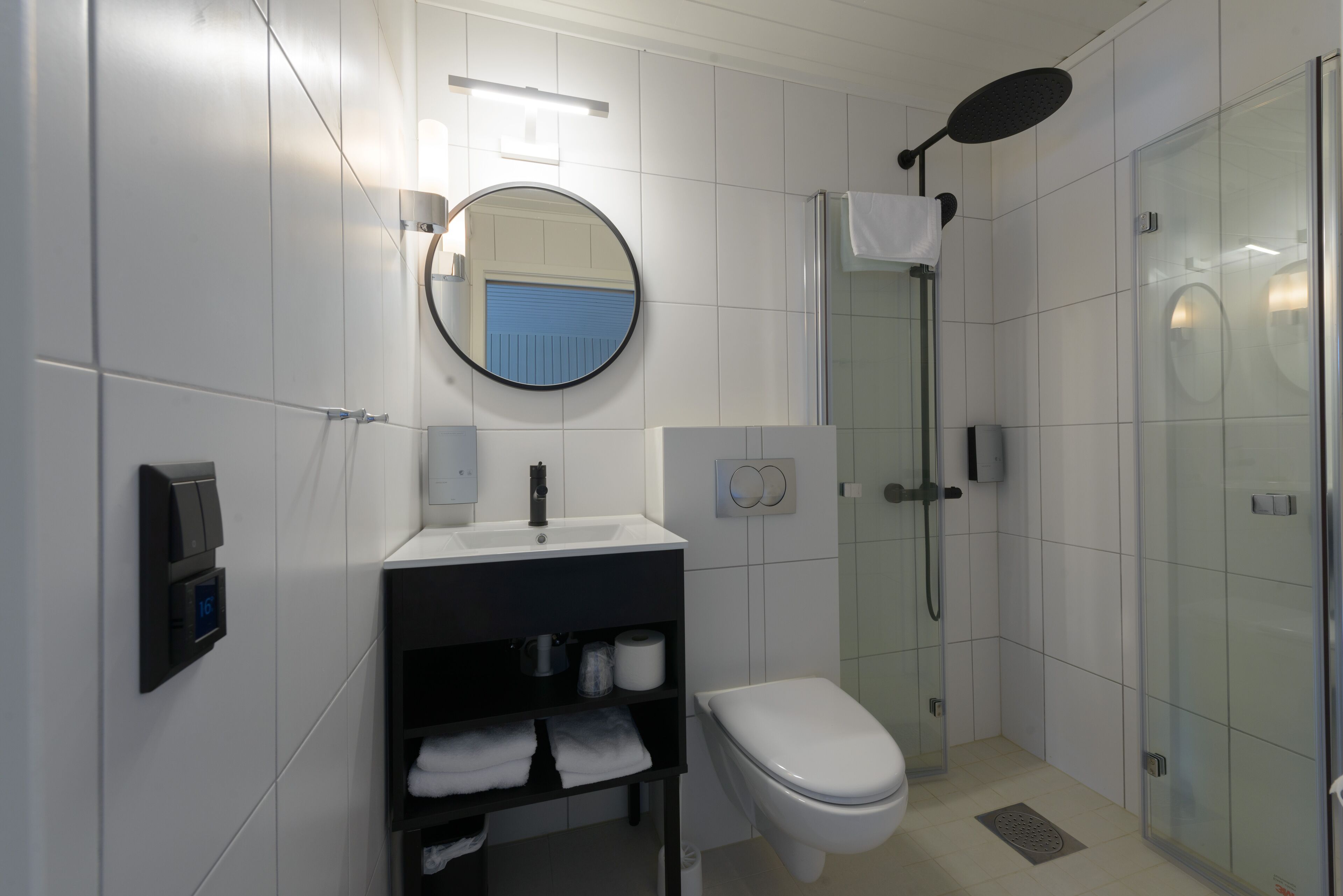 Un baño moderno con inodoro, lavabo y ducha.
