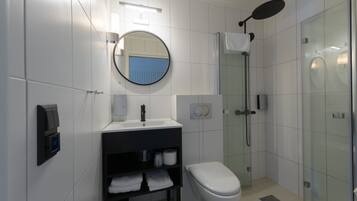 Un baño moderno con inodoro, lavabo y ducha.