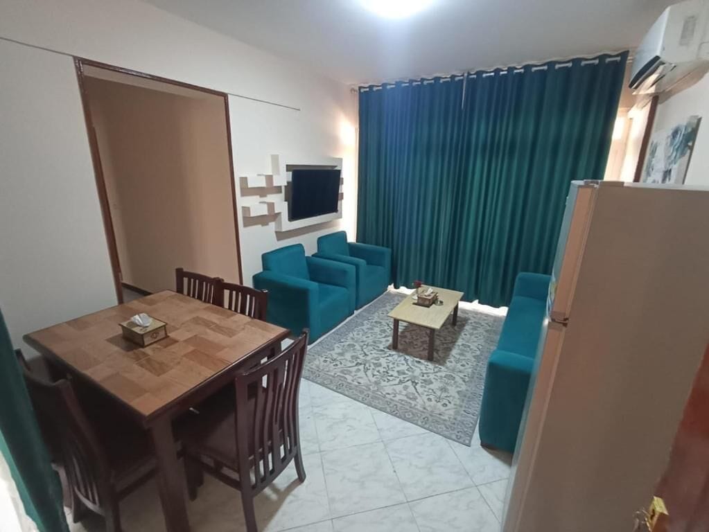 Un espacio habitable compacto con comedor, un sofá y una pequeña mesa de centro.