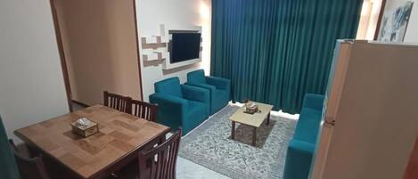 Un espacio habitable compacto con comedor, un sofá y una pequeña mesa de centro.