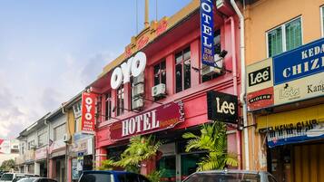 A hotel with a prominent 'OYO' sign, a 'Gold Star Hotel' sign, and a 'Lee' sign for footwear.