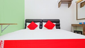 A bed with a white and red bedspread, two red pillows, and a black headboard. - OYO 850 Gold Star Hotel (Chukai)