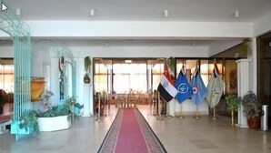 En lobby med rødt tæppe, flag og moderne indretning.
