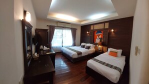 Habitación de hotel con dos camas, un escritorio, un espejo y un cuadro en la pared.