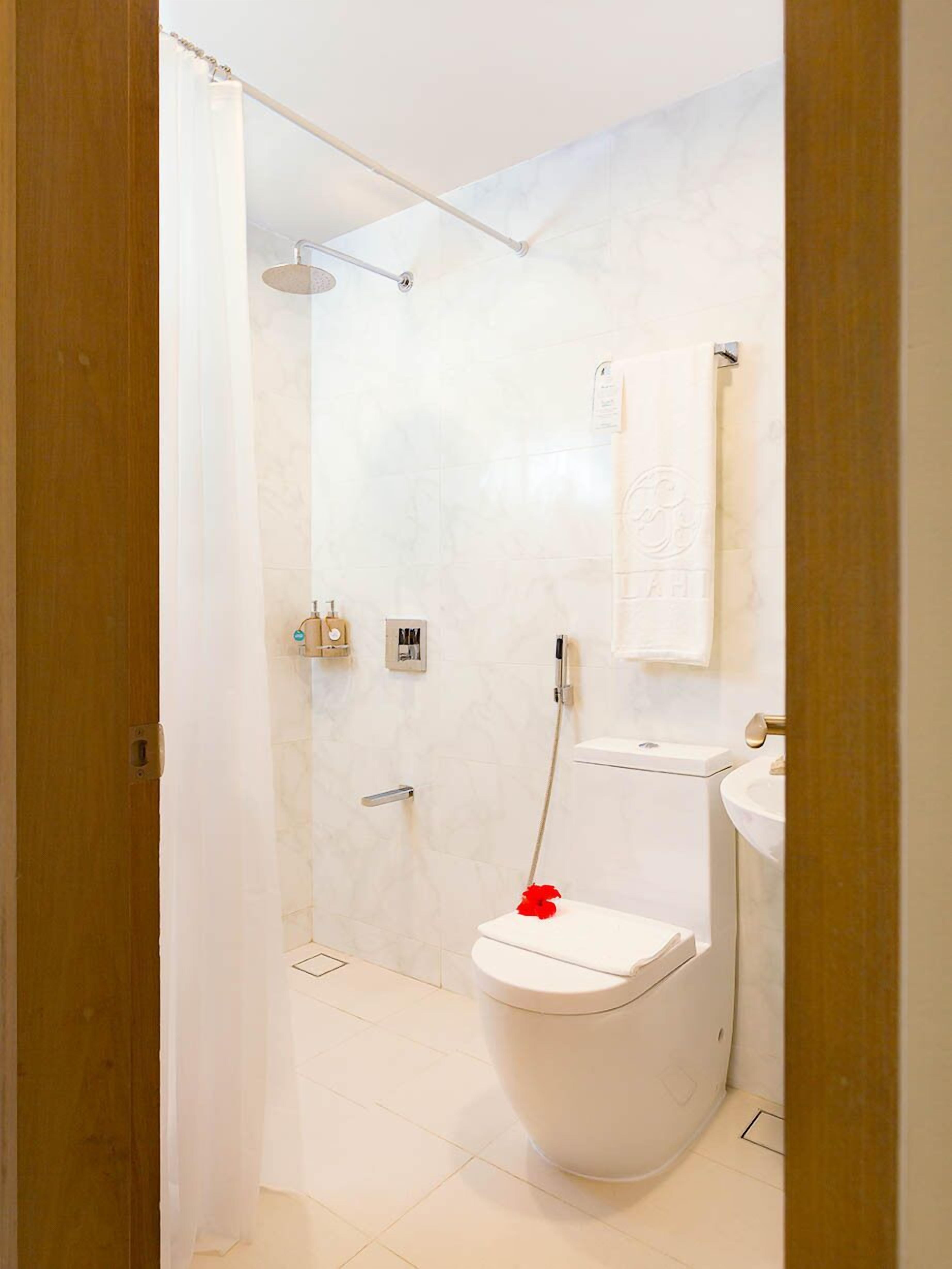 Een moderne badkamer met een douche, toilet en wastafel.