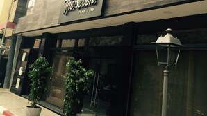 A hotel named "The Seven" with a modern facade, large windows, and potted plants in front. - The Seven Hotel and Spa (Casablanca)
