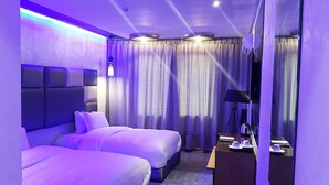 A modern hotel room with two beds, a large mirror, and a bedside table with a lamp. - The Seven Hotel and Spa (Casablanca)