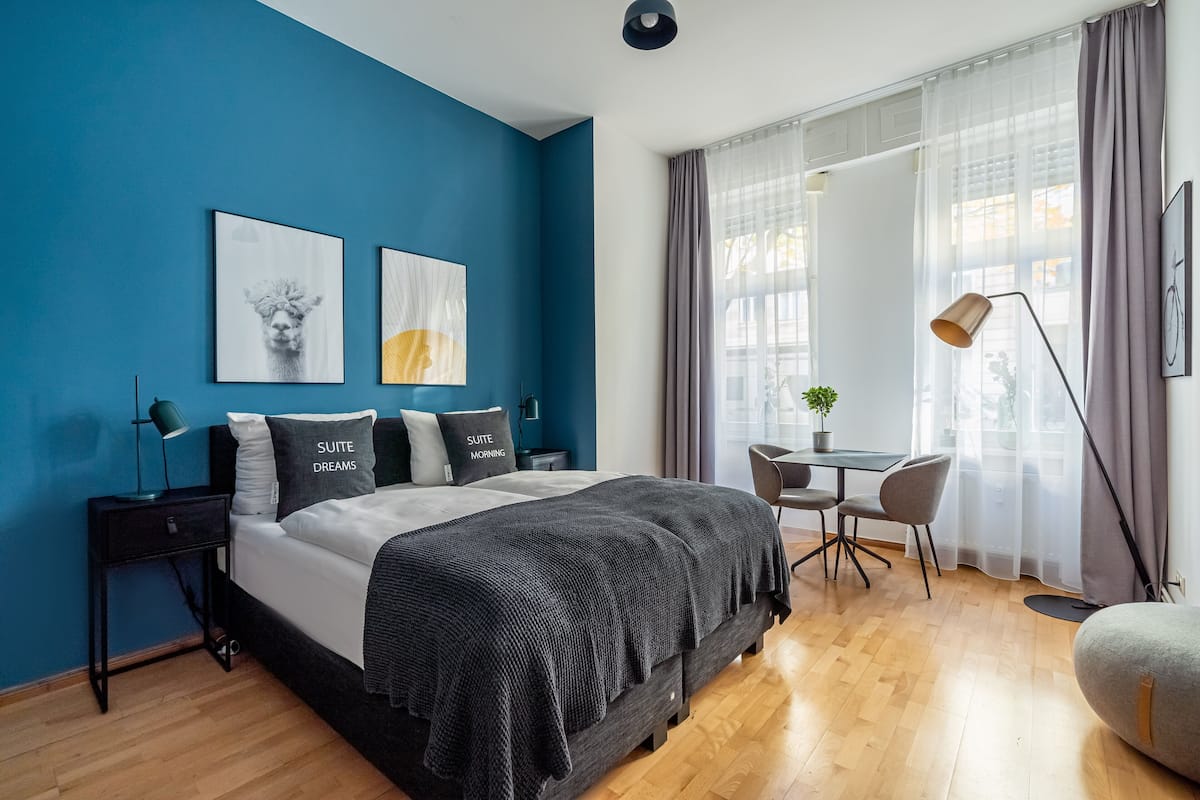 A modern bedroom with a large bed, a desk, and a chair.