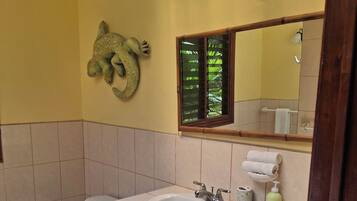 Un baño con inodoro, lavamanos y un perchero para toallas.