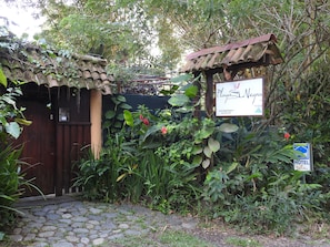 Ein rustikales Holztor mit einem Schild für das Playa Negra Gästehaus.