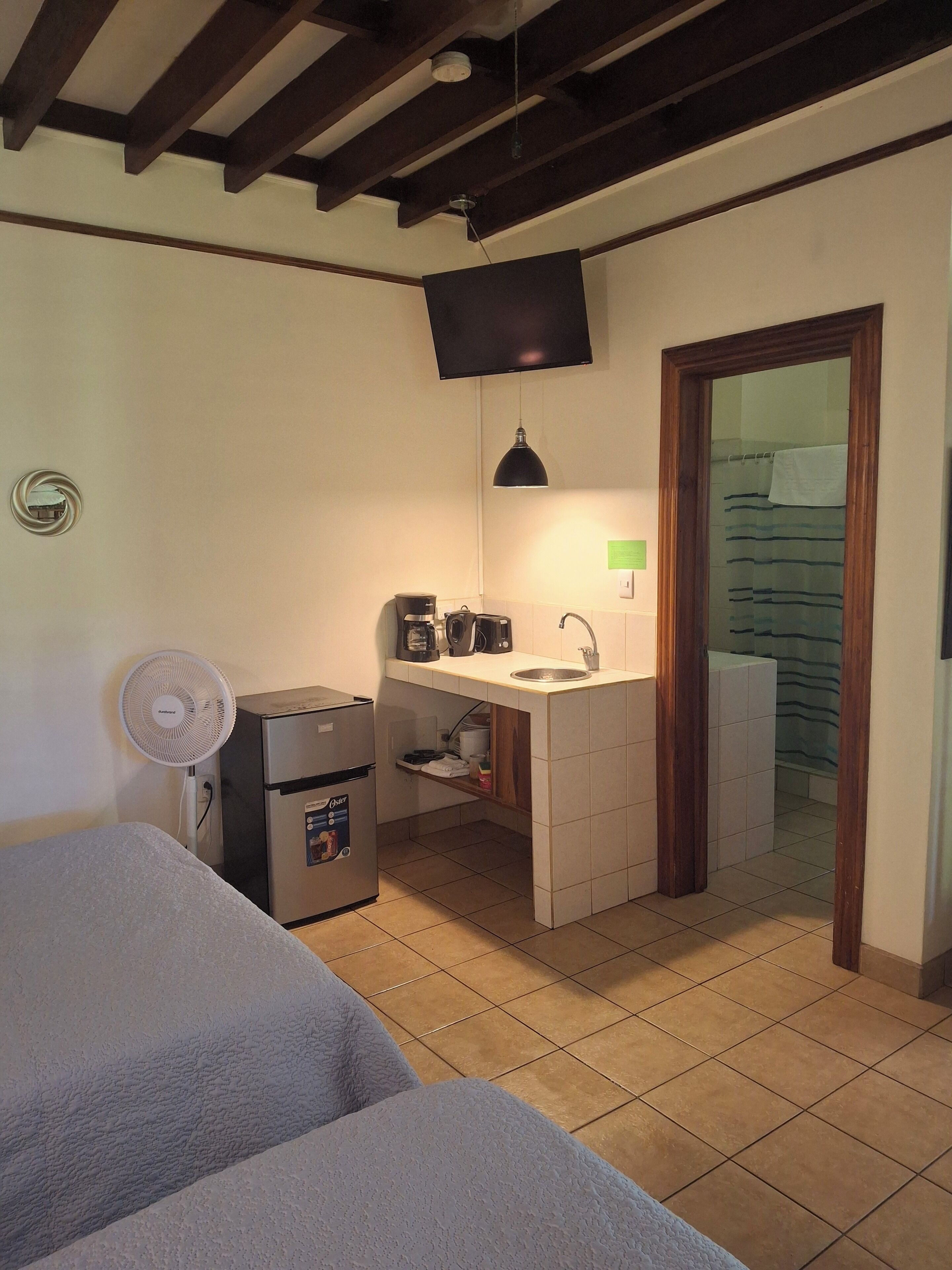 A compact kitchen with a sink, a coffee maker, and a refrigerator.