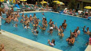 Alberca al aire libre, sombrillas en la alberca y camastros