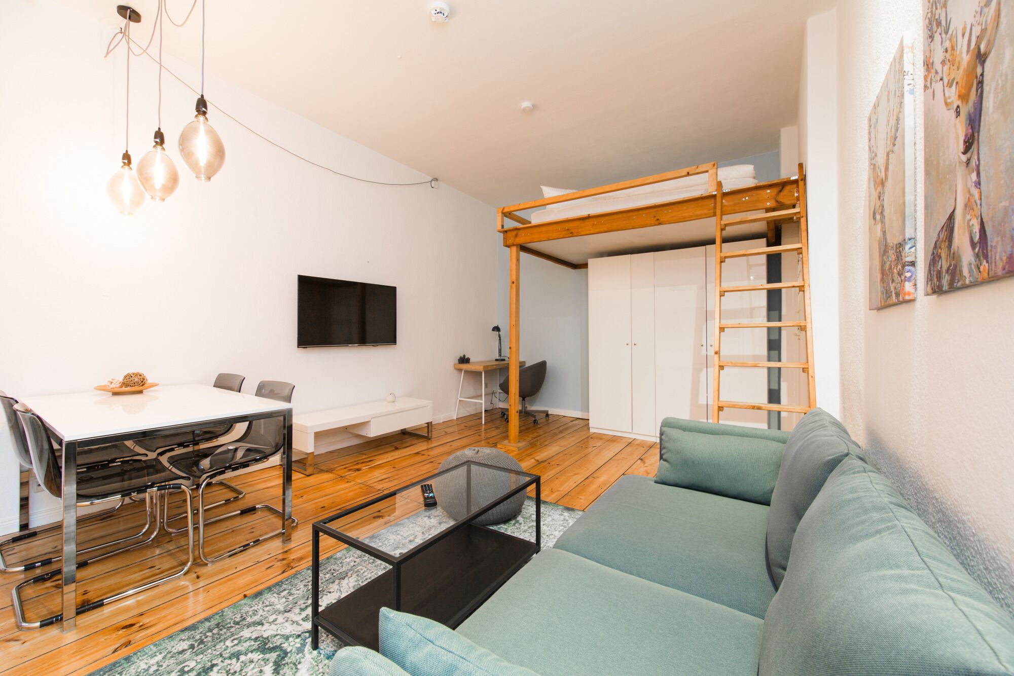 A modern living room with a bunk bed, a dining area, and a TV.